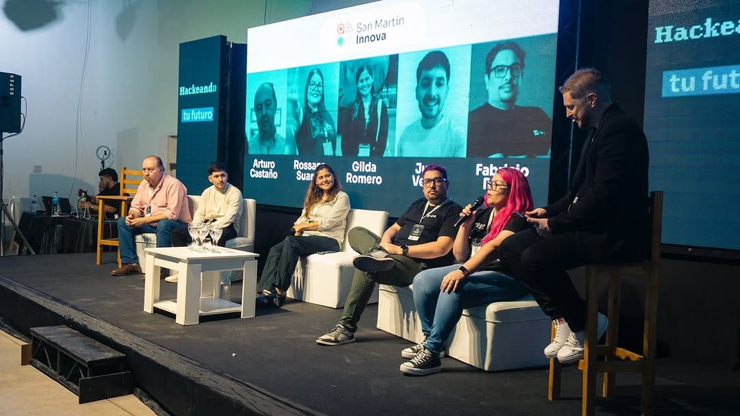 Panel con oradores en pantalla LED durante el evento