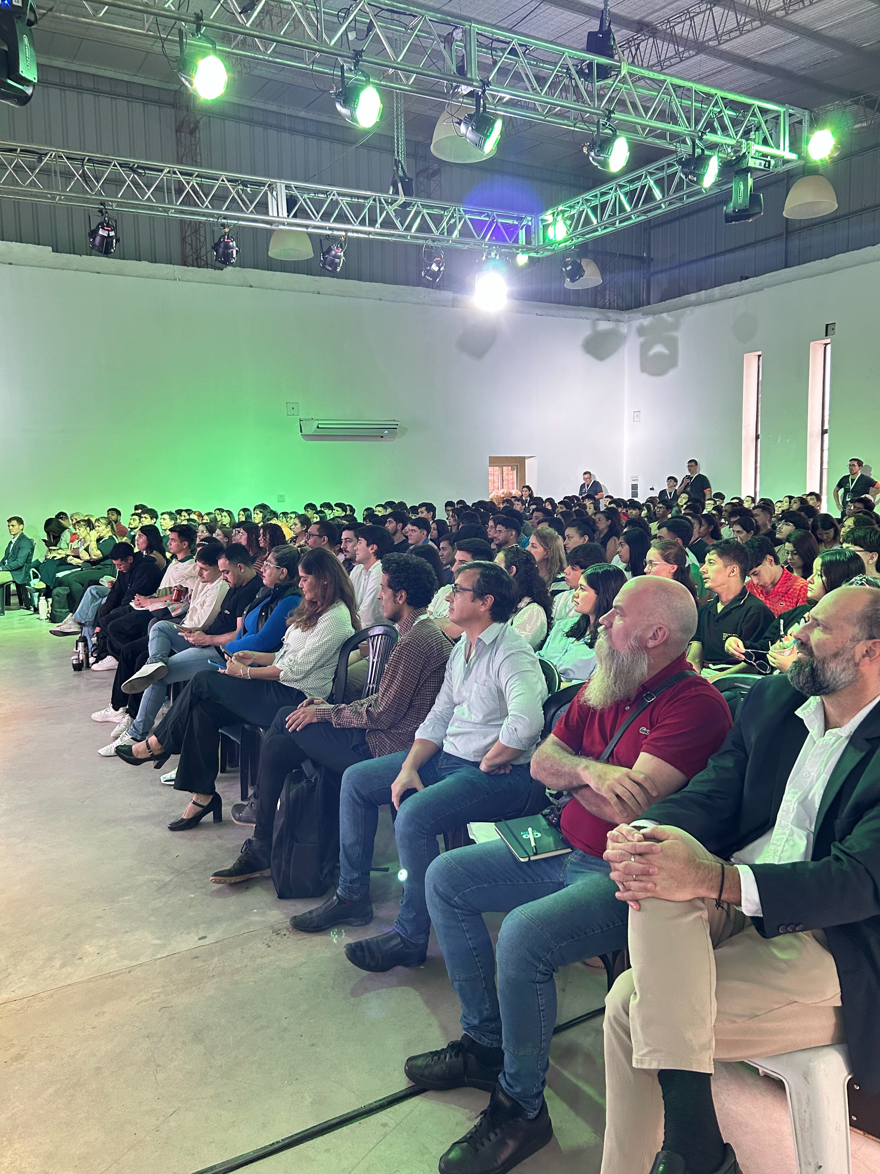 Auditorio iluminado con luces verdes durante una charla